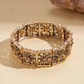 Detailed macro of vintage gold floral metal links with amber gemstone inlay and elastic band - Hollow Floral Style With Amber Rhinestone / Gold