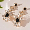 Macro view of geometric flower drop earrings with clear and black crystal rhinestones - Silver Pin-Gold Rhinestone Flower Drop Earrings