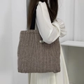 Detail of herringbone canvas tote bag with black strap and brand label on shoulder - Woolen Stripe Brown