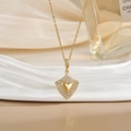 Close-up of heart-shaped shield pendant with sparkling crystals on a golden necklace - Gold Shield Heart Zirconia Style (XL0469)