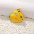 Macro shot of gold-plated fish pendant with colorful enamel dots on coral background - A0175 Yellow Fish