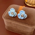 Gros plan des boucles d'oreilles fleurs en émail bleu avec diamants sur velours - 20# Boucles d'oreilles clous fleur épanouie en émail avec tige en argent