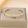 Two-tone silver and 18K gold plated stainless steel knot bracelet on jewelry box - Bi-Color Knot Clasp Cuff Bracelet (KB1862271-KFC)