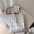 Detail of floral printed cotton tote bag with sturdy shoulder straps on white table - White With Navy Blue Small Flowers