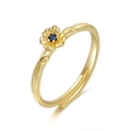 Detalle de un anillo floral dorado con piedra azul y textura de vid en el aro - Febrero