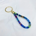 Ethno-Schlüsselanhänger mit bunt gewebtem Stoffarmband in Blau und Gelb und Goldring - Blaugrüner Ethno-Stil