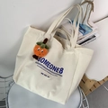 Detail of off-white canvas tote bag with Someone8 blue print and a cute plush charm - SOMEONE (with Orange Charm)
