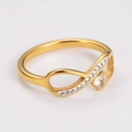 Detailed close-up of gold infinity ring with sparkling heart crystal and paved stones - US 6 / Gold