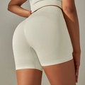 Dettaglio dei pantaloncini da yoga a vita alta senza cuciture con effetto push-up modellante - Crema