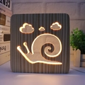 3D wooden hollow snail and cloud LED night light with warm yellow glow on white desk - Snail/15cm