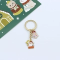 Detail of golden metal keychain featuring pink Christmas tree and Santa Claus charms - Chimney Santa & Pink Xmas Tree