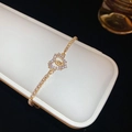 Sparkling gold tennis bracelet featuring a layered double heart charm and zircon inlay - Gold Interlocking Double Heart Style (Bracelet-Gold-Heart)