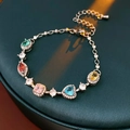 Detailed shot of multi-color gemstones on silver chain bracelet over dark teal background - Bracelet - Colorful Heart