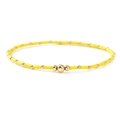 Close-up of yellow beaded bracelet with gold accents and elastic cord for secure fit - Yellow