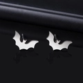 Gros plan de boucles d'oreilles chauve-souris argentées avec une surface polie brillante - Stud boucles d'oreilles / Argenté