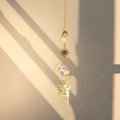 Close-up of brass fairy suncatcher with crystal ball reflecting rainbow light on wall - Elf
