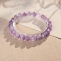 Détail du bracelet en perles d'améthyste avec textures naturelles sur surface beige chaud - Style Perles d'Améthyste (8mm - Coffret Cadeau Exquis)