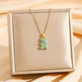 Detailed shot of gold bear necklace with blue crushed stones in a premium jewelry box - Gold Turquoise