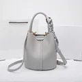 Light grey pebble leather bucket bag with silk scarf handle and golden hardware details - Premium Grey