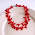 Detailed view of red layered beaded necklace with bamboo-style glass beads in a ceramic tray - Red