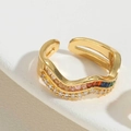 Detail van gouden golvende open ring met gekleurde baguette stenen en witte zirkoon - Kleurrijke Zirconia Holle Stijl