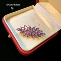 Detailed macro view of amethyst zircon brooch in a red gift box with dimensions 4.4x1.9cm - D099 Purple