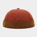 Detail of cotton patchwork brimless docker hat in rust red and dark brown color tones - Orange With Caramel Edge