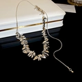 Close-up of a silver leaf tassel necklace elegantly placed on a white jewelry gift box - Silver