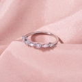 Macro-opname van zilveren ring met ronde en marquise zirkoon op roze zijde - Zilveren Marquise Zirkonia