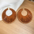 Détail de créoles géométriques tressées marron sur un fond en bois rustique élégant - Grand / Brun doré