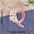 Pink embroidered letter Q patch with delicate floral details and precise dimensions - Letter Q / Hot Melt Adhesive