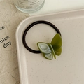 Détail de l'élastique à cheveux papillon en acétate avec inscription France Handmade dorée - Vert