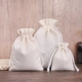 Three sizes of cream white linen drawstring jewelry pouches on natural wood background - 7*9cm / Off White