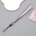 Close-up of a purple rhinestone phone wrist strap with leather and metal accents - Wrist Strap / Purple
