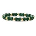Close-up of green bamboo-shaped stone beads and polished gold metal spheres on the bracelet - Malachite