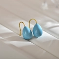 Elegant light blue water-drop earrings with gold hooks on white leather background - Sky Blue