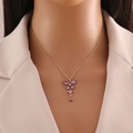 Golden butterfly necklace with purple gemstone pendant and tassels worn on neck - Purple