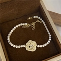 Elegant golden bracelet featuring a camellia flower pendant set with clear crystals - Gold Flower Style