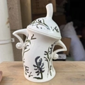 White ceramic canister with blue and green plant patterns and lid featuring unique handles - New Plant Ceramic