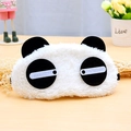 Dettaglio della morbida maschera per dormire a forma di panda su sfondo in legno - Occhi Socchiusi