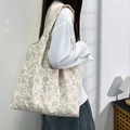 Floral canvas tote bag with blue patterns shown on model's shoulder in natural light - Pastoral Small Floral