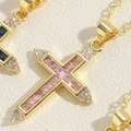Vista macro del ciondolo a croce placcato oro 14K con zircone rosa e pietre decorative - Rosa