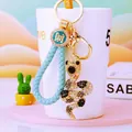 Detail view of crystal snake keychain with light blue braided strap and lucky charm - Light Blue Lucky Rope + Dark Blue Snake