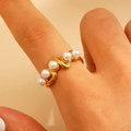 Detail of gold-plated stainless steel ring featuring S-shaped waves and five white pearls - Wavy Pearl Alignment (10880)