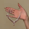 Detail eines luxuriösen Schmucksets mit roten Edelsteinen in Tropfenform und Glitzerkette - Silberne Basis mit Rotem Stein (Halskette Ohrring Set)
