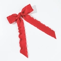 Macro detail of red satin bow hair clip featuring ruffled edges and elegant long ribbons - Red