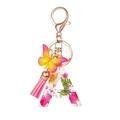 Portachiavi lettera A in resina con fiori secchi rosa e gialli, farfalla e nappa - Motivo Floreale A