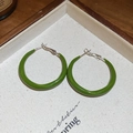 Detail view of grass green enamel C-shaped hoop earrings on a light fabric tray - Silver and Green Splicing Style (Silver Earring Post)