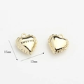 Macro shot of 15mm gold heart charm with Sweetie engraving and scalloped edges - Heart / Gold