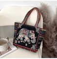 Ethnic style black canvas tote bag featuring colorful elephant embroidery on a white chair - Black White Elephant
